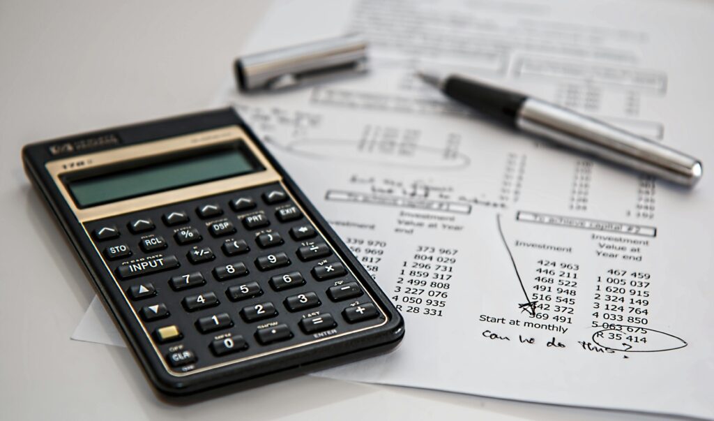 Home Close-up of financial documents with calculator and pen, ideal for business management themes.