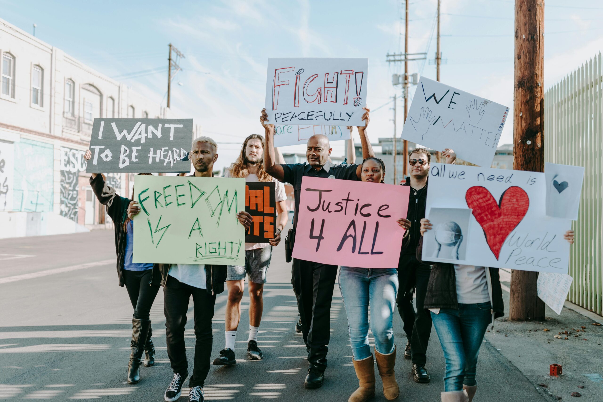 Advocacy & Legislation Group of activists hold signs advocating for justice and equality during a street protest.